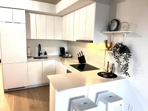 uma cozinha branca com armários brancos e um balcão em App en Plein Centre de Montréal - Quartier des Spectacles em Montreal