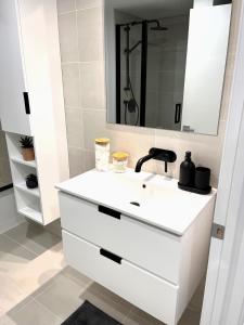 ein weißes Badezimmer mit einem Waschbecken und einem Spiegel in der Unterkunft App en Plein Centre de Montréal - Quartier des Spectacles in Montreal