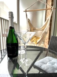 uma garrafa de champanhe e um copo de martini numa mesa de vidro em App en Plein Centre de Montréal - Quartier des Spectacles em Montreal