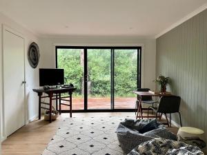 a living room with a couch and a desk and a television at Bangalla Inlet Side in Inverloch