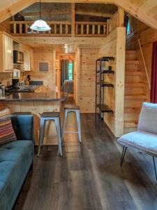 una cucina e un soggiorno in una baita di tronchi di Ani Cabin Tiny Home Bordered By National Forest a Chattanooga