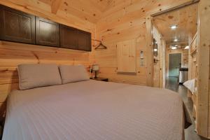 a bedroom with a bed in a wooden cabin at Ani Cabin Tiny Home Bordered By National Forest in Chattanooga