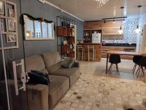 a living room with a brown couch and a kitchen at Casa na praia p aproveitar com a família e amigos in Capão da Canoa +7 photos