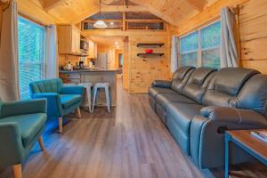 a living room with a couch and chairs and a kitchen at Ernie Cabin Wauhatchie Woodlands Tiny Cabin in Chattanooga