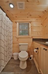 a bathroom with a toilet in a wooden cabin at Ernie Cabin Wauhatchie Woodlands Tiny Cabin in Chattanooga