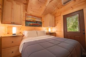 ein Schlafzimmer mit einem Bett in einer Holzhütte in der Unterkunft Ernie Cabin Wauhatchie Woodlands Tiny Cabin in Chattanooga