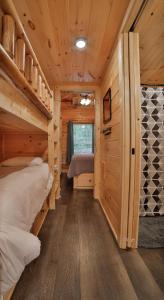 a bedroom with two bunk beds in a log cabin at Eden Cabin Forested Tiny Home On Lookout Mtn in Chattanooga