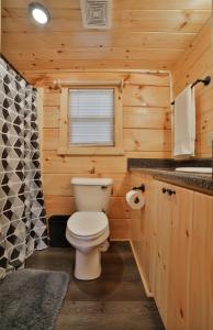 Baño con aseo blanco en una cabaña de madera en Eden Cabin Forested Tiny Home On Lookout Mtn, en Chattanooga