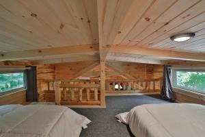 a bedroom in a log cabin with two beds at Bryce Cabin Lookout Mtn Tiny Home W Swim Spa in Chattanooga