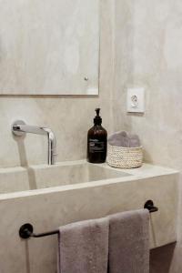 a bathroom sink with a bottle of soap on it at The Room Padang-Padang in Uluwatu