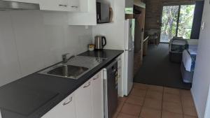 a kitchen with a sink and a counter top at Emeraldene Inn & Eco-Lodge in Hervey Bay