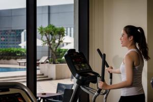 a woman running on a treadmill in a gym at Odin Hotel Quy Nhon in Quy Nhon +144 photos