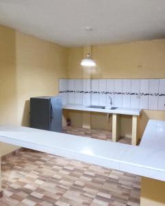 a large kitchen with a white counter top and a refrigerator at Departamento de Pablito Junto al Mar in Caleta Cruz
