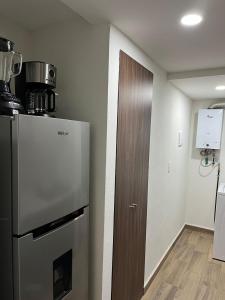 a kitchen with a refrigerator and a wooden door at Departamento nuevo a 5 cuadras de Roma Norte in Mexico City