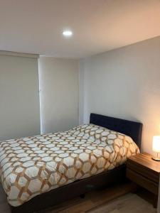 a bedroom with a bed in a room with a table at Departamento nuevo a 5 cuadras de Roma Norte in Mexico City