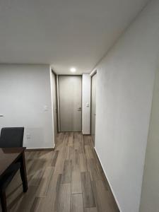 an empty hallway with white walls and wooden floors at Departamento nuevo a 5 cuadras de Roma Norte in Mexico City