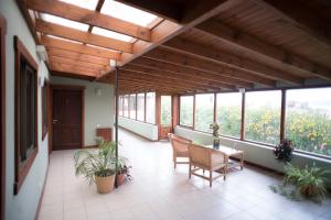 a porch with a table and chairs and windows at Hotel Austral Ushuaia in Ushuaia