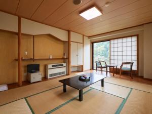 un soggiorno con tavolo e una sala da pranzo di Tabist Nikkokinugawa Onsen Kiyomizu no Yado a Nikko