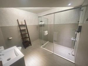 a bathroom with a glass shower and a sink at Baishawan Marina B&B in Shimen
