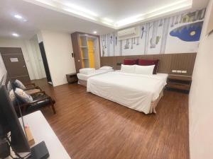 a hotel room with a large bed and a television at Baishawan Marina B&B in Shimen