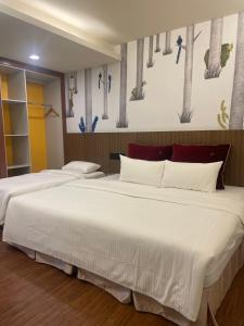 a bedroom with two beds with white sheets at Baishawan Marina B&B in Shimen