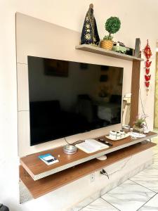 een grote flatscreen-tv aan de muur bij Apartamento pra galera ou família in São Vicente