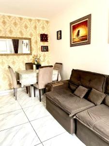 een woonkamer met een bank en een tafel bij Apartamento pra galera ou família in São Vicente