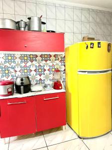 een keuken met twee rode en gele apparaten bij Apartamento pra galera ou família in São Vicente