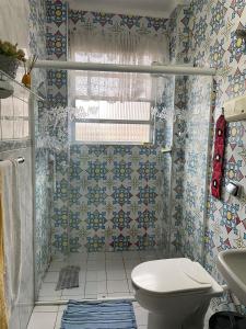 een kleine badkamer met een toilet en een raam bij Apartamento pra galera ou família in São Vicente