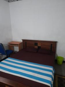 a bedroom with a bed with a blue and white stripes at Smart Holiday Inn in Galle