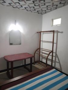 a room with a bed and a table and a lamp at Smart Holiday Inn in Galle