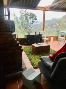 a living room with a couch and a table and a tv at Cabaña de descanso en la montaña in Mongua