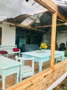 eine Terrasse mit weißen Tischen und Stühlen in einem Gebäude in der Unterkunft Cabaña de descanso en la montaña in Mongua