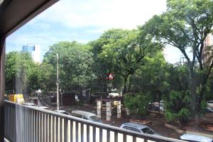 a balcony with a view of a parking lot with cars at Apartamento 80 O´H Aparthotel. in Ciudad del Este