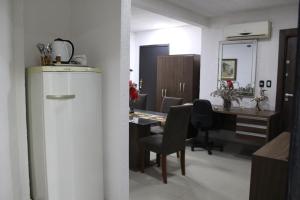 a kitchen with a desk and a refrigerator in a room at Apartamento 80 O´H Aparthotel. in Ciudad del Este