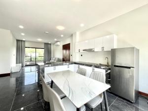 uma cozinha com uma mesa branca e cadeiras em SKYVIEW Residence & Apartments Sihanoukville em Sihanoukville