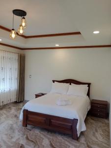 a bedroom with a large bed with white sheets at villa saturia in Ráquira