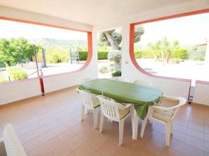a dining room with a green table and white chairs at Viila near Syracuse in Siracusa in Siracusa