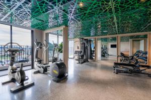 ein Fitnessstudio mit Laufbändern und Trainingsgeräten in einem Gebäude in der Unterkunft L'amor Boutique Hotel Quy Nhơn in Quy Nhon