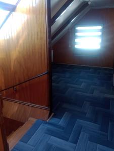 een lege kamer met een houten deur en een trap bij Isla yu backpacker in Puerto Natales