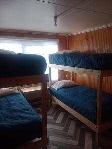 納塔列斯港的住宿－Isla yu backpacker，客房设有三张双层床和一扇窗户。