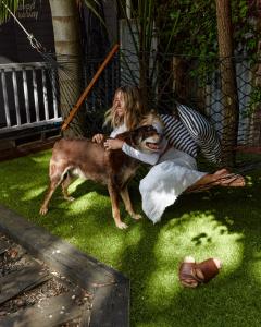 Una mujer acostada en la hierba con un perro en Yallingup Lodge Spa Retreat, en Yallingup