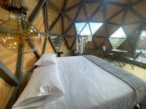 a bedroom with a bed in a wooden room at Vitta Glamping in Rionegro