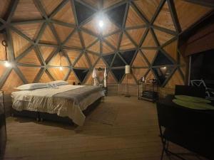 a bedroom with a large bed in a wooden room at Vitta Glamping in Rionegro