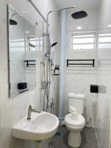 a white bathroom with a toilet and a sink at Happi Homestay@Taman Saga in Bentong +9 photos