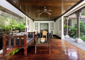 a living room with a ceiling fan and a table at Kayumanis Ubud Private Villas & Spa in Ubud