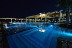 a swimming pool with blue lights in the night at Hotel New Star in Skopje