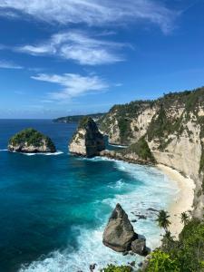 珀尼達島的住宿－Kesari Glory Nusa Penida by Pramana Villas，享有海滩和海洋岩石的景色