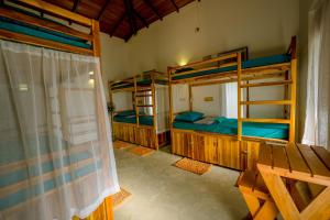 a room with three bunk beds and a window at Sixth Sense Hostel in Galle