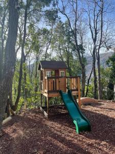 un pequeño parque infantil con un tobogán en el bosque en Acogedora cabaña con tinaja libre para disfrutar, en Las Trancas